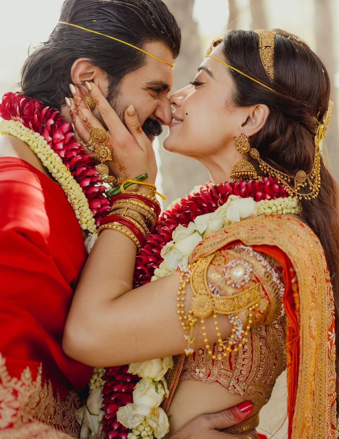 Rashmika Mandanna holding Vijay Deverakonda close in an intimate moment with red rose garlands and mehendi visible